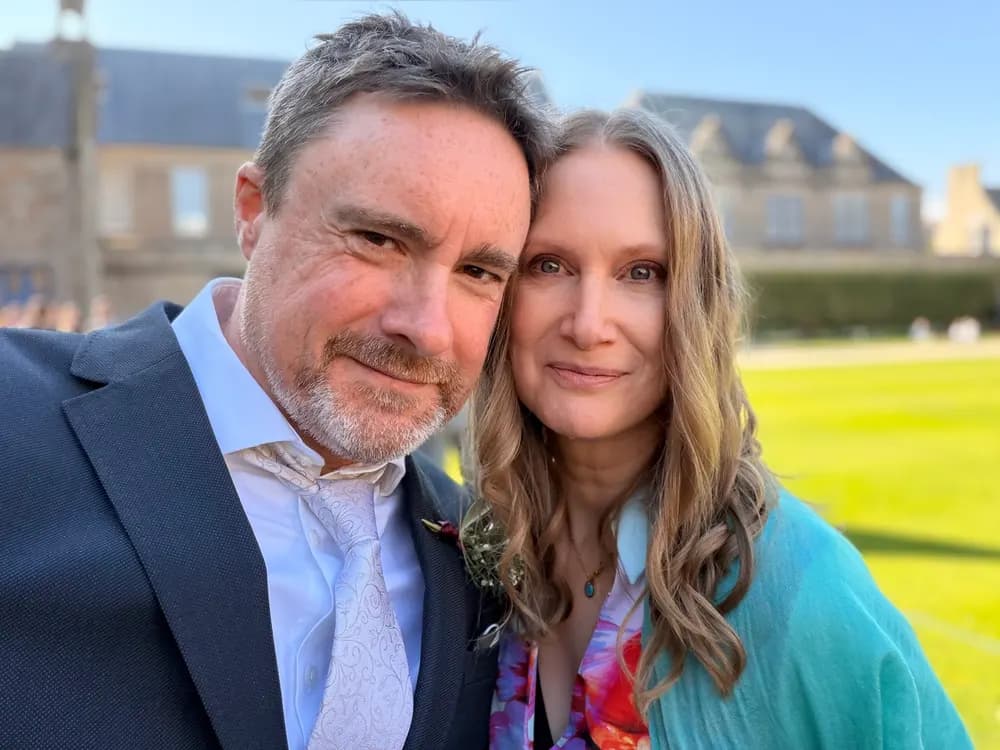 Matt and Sharon Edmundson standing cheek to cheek outdoors