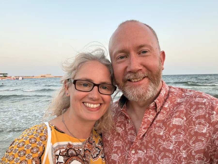 Dan and Lisa Orange smiling together on a beach at sunset